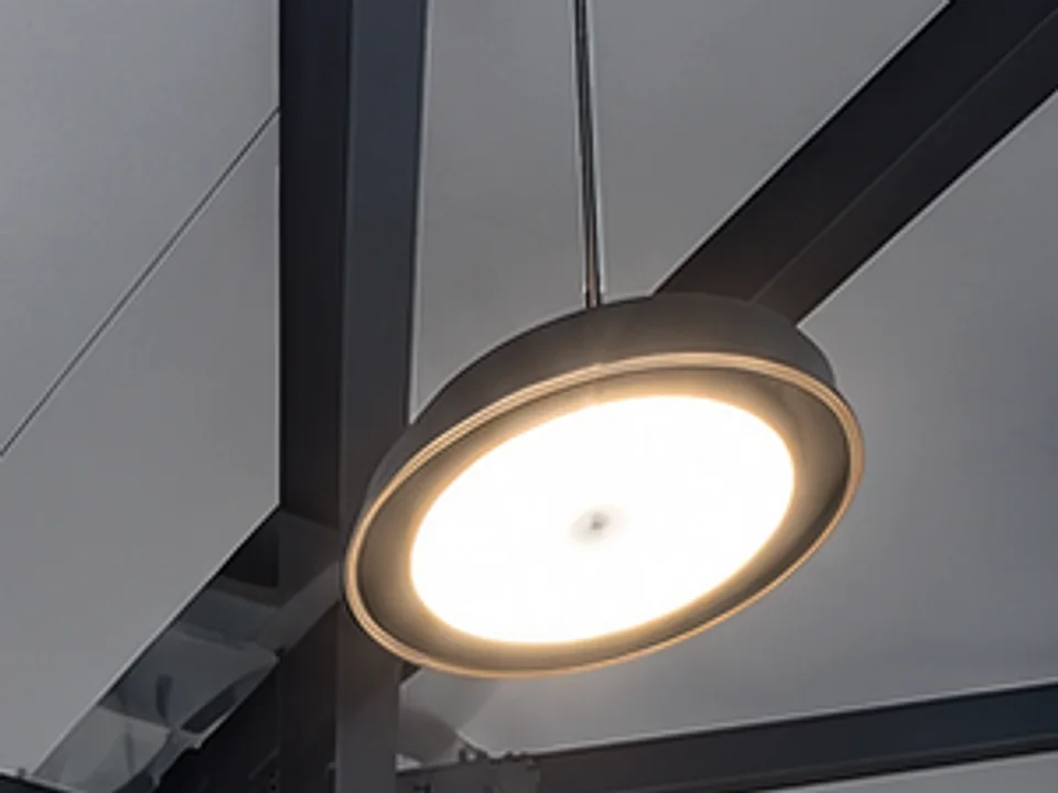 Close-up of a ceiling light fitted at Villa G28, neatly suspended between black steel beams