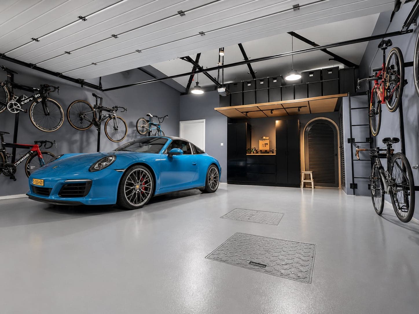 Wide view of the finished G28 garage: air-conditioning unit, epoxy floor, bike racks and mezzanine with cabinets beneath