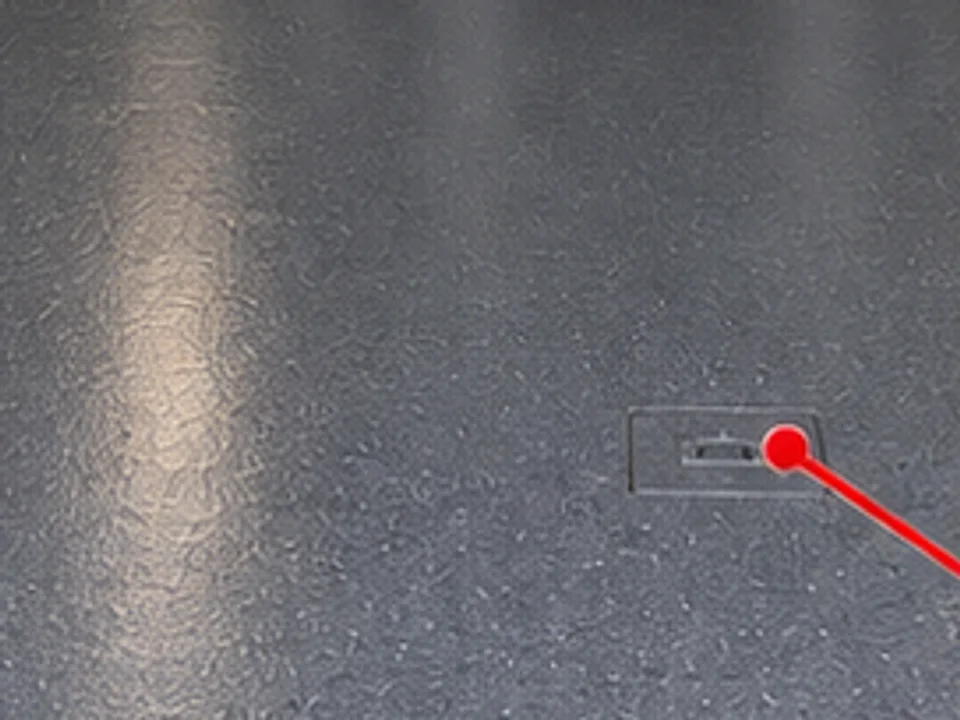Close-up of the dark-grey speckled epoxy floor in the package illustration, with a floor access cover finished to match