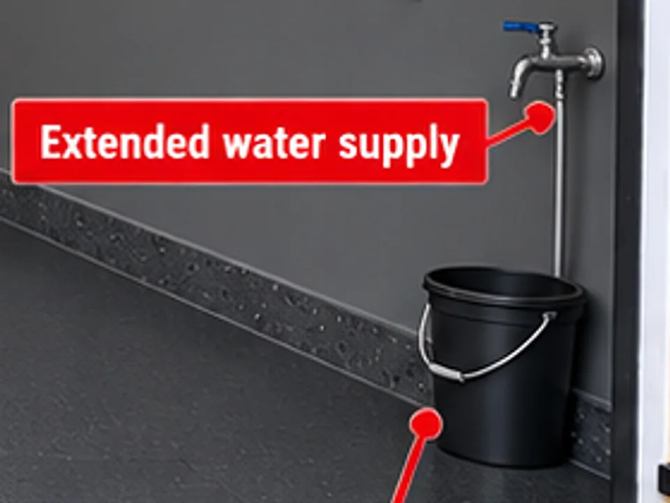 Close-up of the new front-garage tap on the side wall in the package illustration, with a bucket beneath it